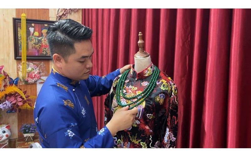 Anh Điển Nguyễn bên một tác phẩm thêu tay của mình.