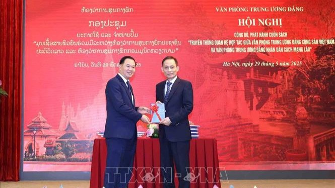 Đồng chí Lê Hoài Trung, Bí thư Trung ương Đảng, Chánh Văn phòng Trung ương Đảng tặng sách cho đồng chí đồng chí Thongsalith Mangnomek, Bí thư Trung ương Đảng, Chánh Văn phòng Trung ương Đảng Nhân dân Cách mạng Lào. (Ảnh: TTXVN) 