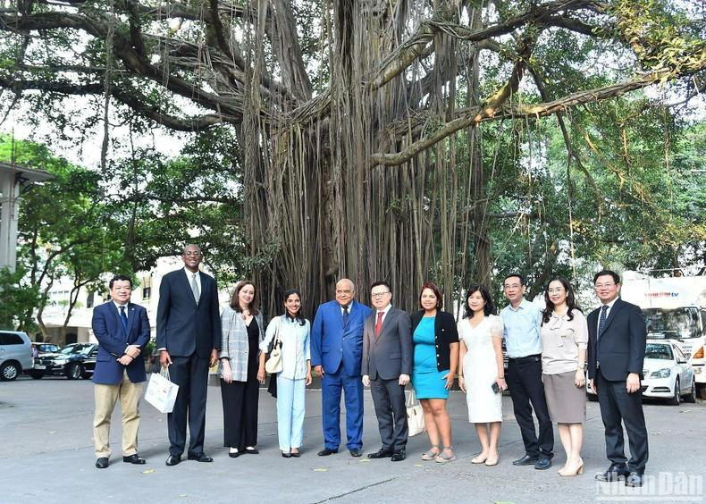 Tổng Biên tập Báo Nhân Dân Lê Quốc Minh và Phó Tổng Biên tập Báo Granma Arlin Alberty Loforte cùng cán bộ của hai cơ quan báo chí chụp ảnh lưu niệm bên gốc cây đa trong khuôn viên Báo Nhân Dân. (Ảnh: THỦY NGUYÊN)