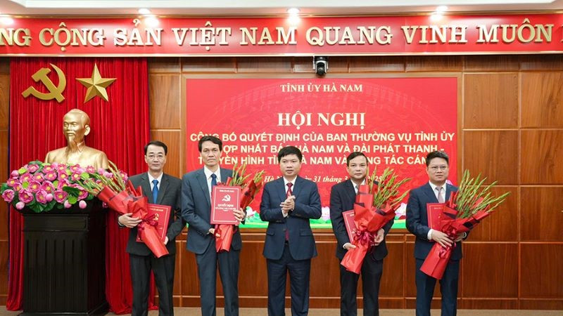 Đồng chí Trương Quốc Huy, Bí thư Tỉnh ủy, Chủ tịch Ủy ban nhân dân tỉnh, Trưởng Đoàn đại biểu Quốc hội tỉnh trao quyết định và tặng hoa chúc mừng Ban Biên tập Báo Hà Nam.
