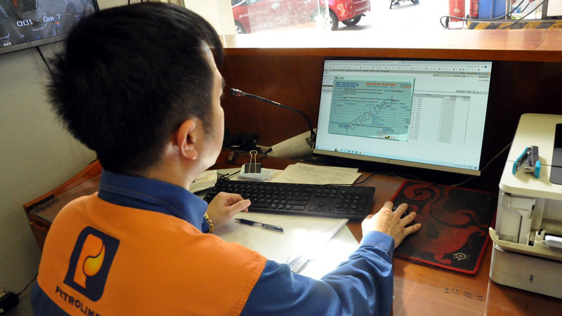 Nhân viên xuất hóa đơn ngay cho khách hàng sau khi mua xăng tại Petrolimex.