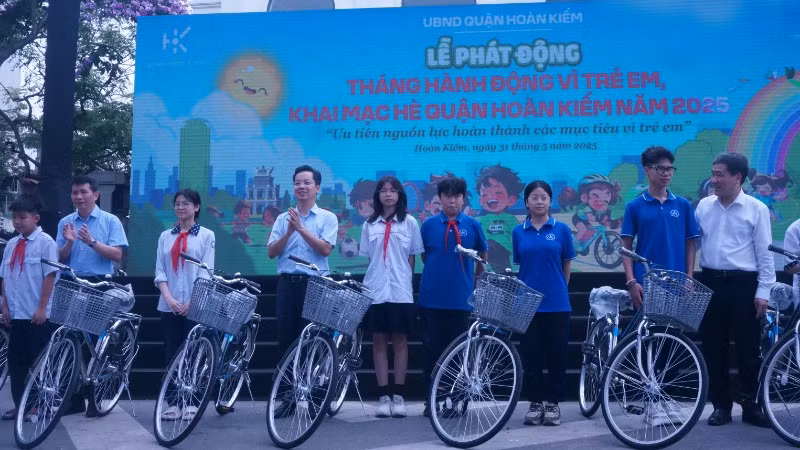 Đại diện lãnh đạo quận Hoàn Kiếm tặng xe đạp cho các em học sinh.