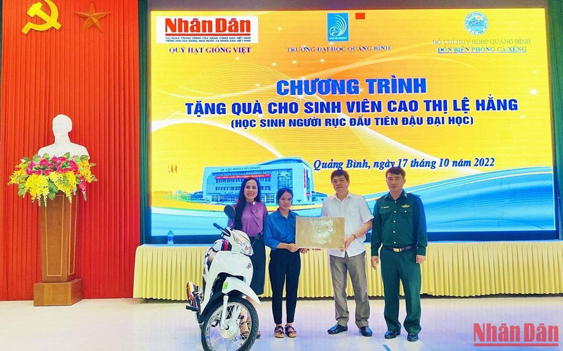 Đại diện Báo Nhân Dân và các đại biểu trao tặng xe máy, máy tính cho sinh viên Cao Thị Lệ Hằng.