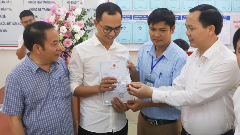 Trao giấy khai sinh và thẻ bảo hiểm y tế theo dịch vụ công liên thông giữa cơ sở dữ liệu về hộ tịch và bảo hiểm. (Ảnh minh họa: TTXVN)