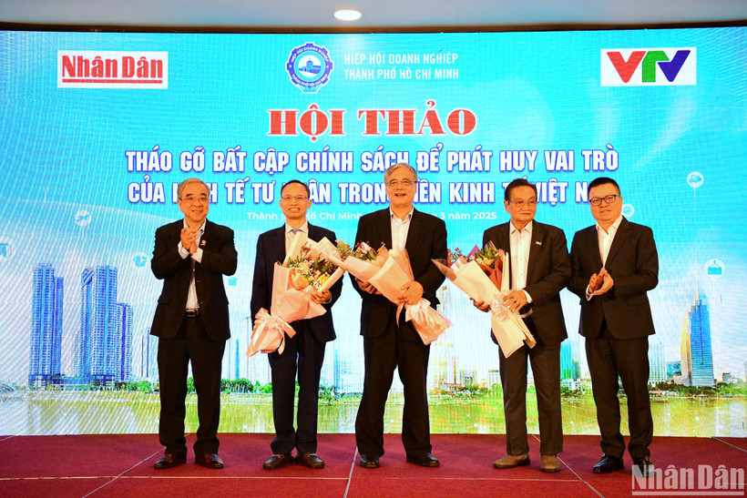 Tổng Biên tập Báo Nhân Dân Lê Quốc Minh và Chủ tịch Hiệp hội Doanh nghiệp Thành phố Hồ Chí Minh Nguyễn Ngọc Hòa tặng hoa cảm ơn các chuyên gia tham dự hội thảo. (Ảnh: THẾ DƯƠNG)