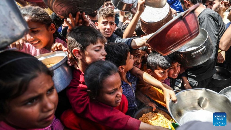 Người dân Palestine nhận thực phẩm miễn phí từ một trung tâm phân phối thực phẩm ở thành phố Gaza, ngày 3/5/2025. (Ảnh: Xinhua) 