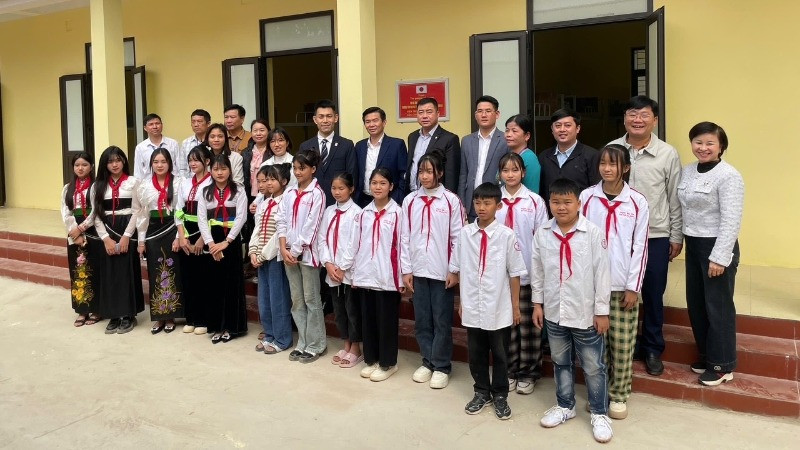 Các đại biểu cùng giáo viên và các em học sinh Trường Tiểu học-Trung học cơ sở Đá Đỏ trước khu nhà bán trú mới hoàn thành. (Ảnh: Đại sứ quán Nhật Bản tại Việt Nam) 