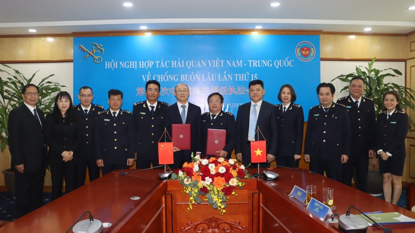 Đại biểu hải quan hai nước trao đổi biên bản ký kết tại hội nghị. (Ảnh: T.Bình) 