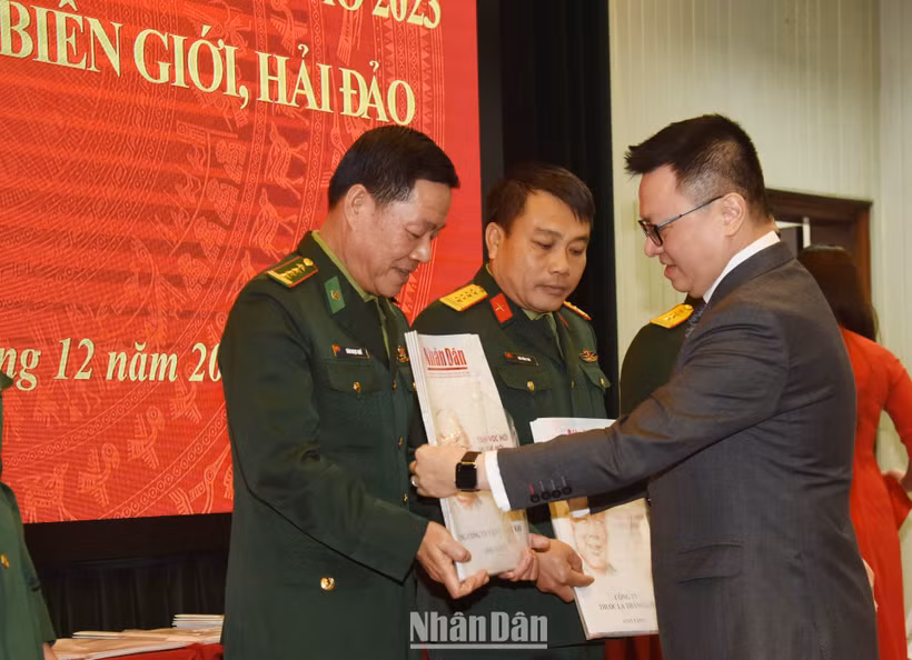 Tổng Biên tập Báo Nhân Dân Lê Quốc Minh trao tặng báo Xuân cho đại diện các đơn vị nhận báo. (Ảnh: TRẦN HẢI)