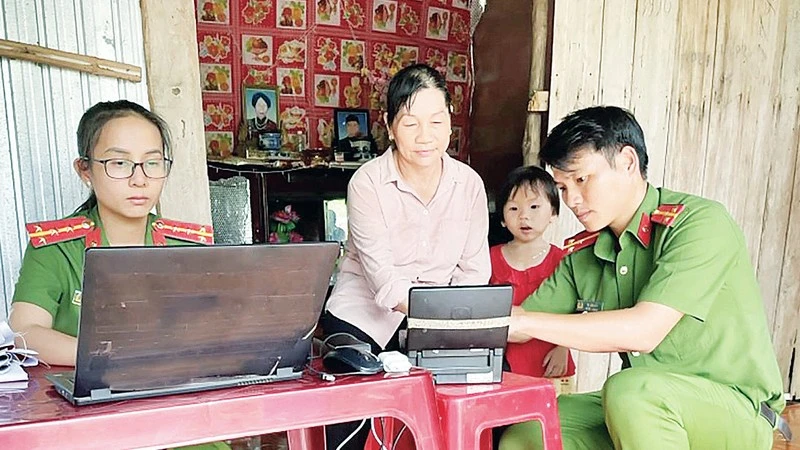 Các chiến sĩ Công an huyện Lộc Ninh đến tận nhà hỗ trợ người dân làm căn cước công dân. (Ảnh: NHẤT SƠN)