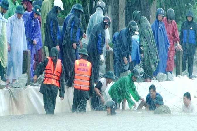 Bộ đội, dân quân tích cực giúp địa phương đắp đê chống sạt lở bờ đê Mai Dương (huyện Quảng Điền).