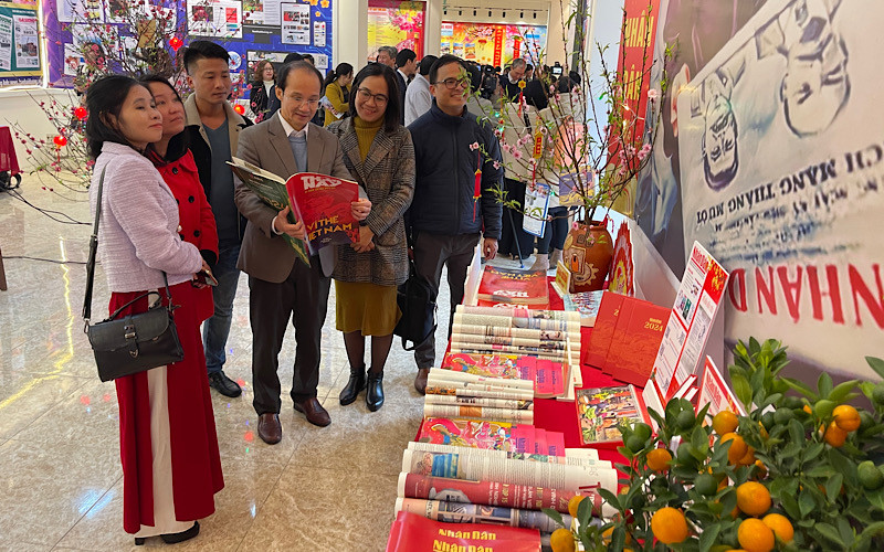 Lãnh đạo và nhiều phóng viên cơ quan báo chí quan tâm đến các ấn phẩm của Báo Nhân Dân.