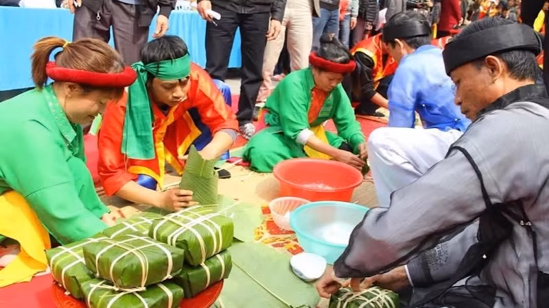 Các nghệ nhân thực hiện phần thi gói bánh chưng.