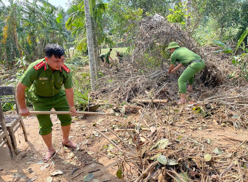 Thượng úy Bùi Văn Hoàng cùng cán bộ chiến sỹ Công an xã Hoà Bắc giúp dân dọn nhà sau bão lũ. Ảnh Công an xã Hoà Bắc