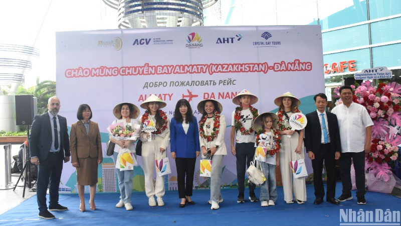 Những hành khách may mắn đầu tiên trên chuyến bay A330/300 đón nhận những phần quà ý nghĩa từ Sở Du lịch Đà Nẵng và các đơn vị liên quan. (Ảnh: ANH ĐÀO)