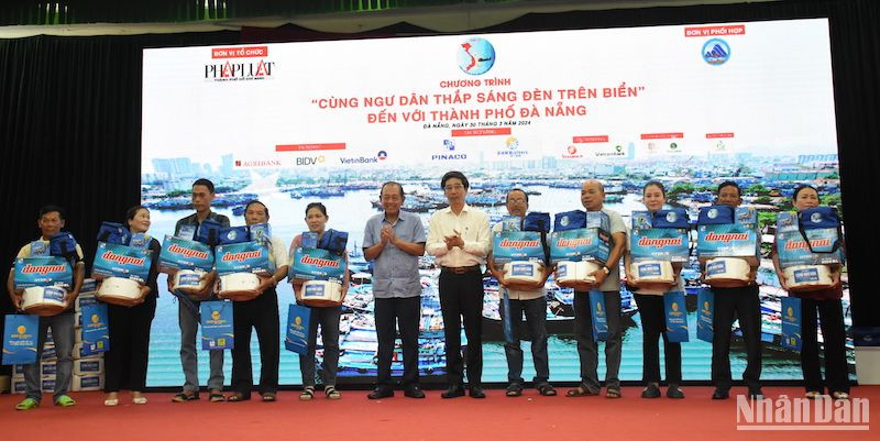 Ông Trương Hòa Bình, nguyên Ủy viên Bộ Chính trị, nguyên Phó Thủ tướng Thường trực Chính phủ, Chủ tịch danh dự của Chương trình và Phó chủ tịch UBND TP Đà Nẵng Trần Chí Cường trao quà hỗ trợ ngư dân Đà Nẵng. (Ảnh: ANH ĐÀO)