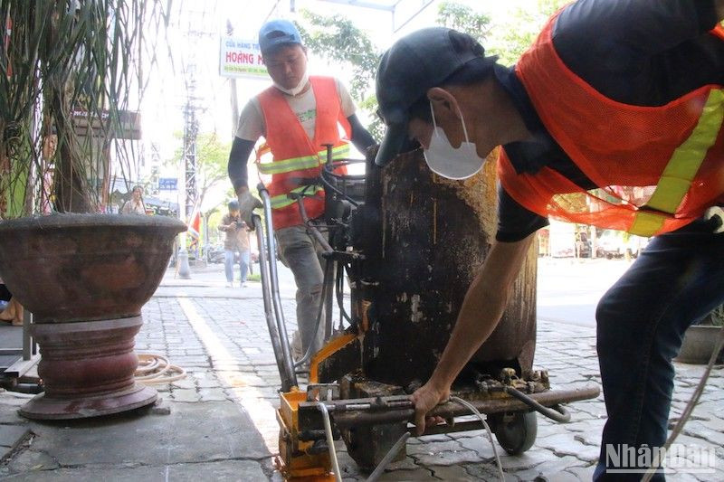 Lực lượng chức năng tiến hành phân định, kẻ vạch trên đường Khúc Hạo, phường Nại Hiên Đông, quận Sơn Trà, chiều 13/3. Ảnh: ANH ĐÀO