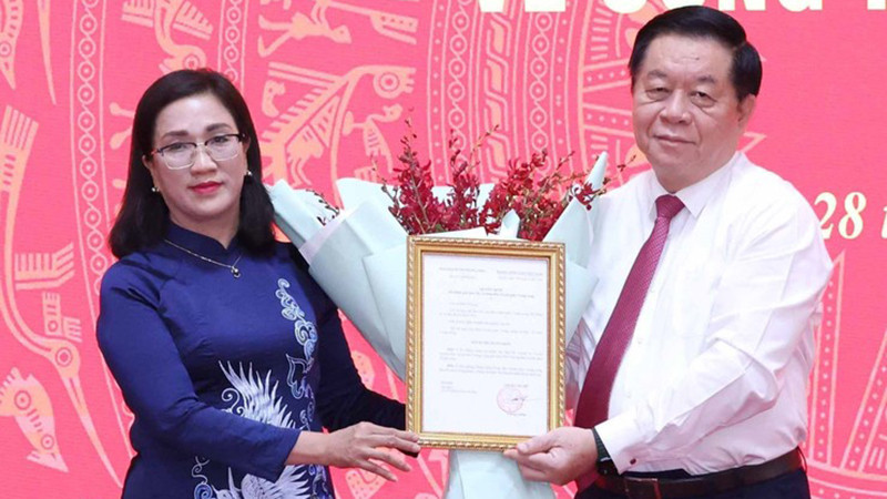 Trưởng Ban Tuyên giáo Trung ương Nguyễn Trọng Nghĩa trao Quyết định cho đồng chí Đinh Thị Mai. (Ảnh: TTXVN)