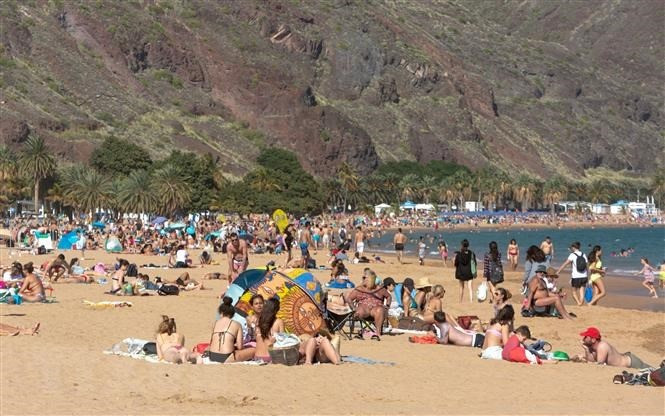 Người dân tránh nóng trên bãi biển ở Santa Cruz de Tenerife, Tây Ban Nha. (Ảnh: AFP/TTXVN)