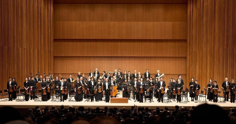 Nhạc trưởng Honna Tetsuji chỉ huy hai dàn nhạc hợp xướng. (Ảnh: TTXVN) 