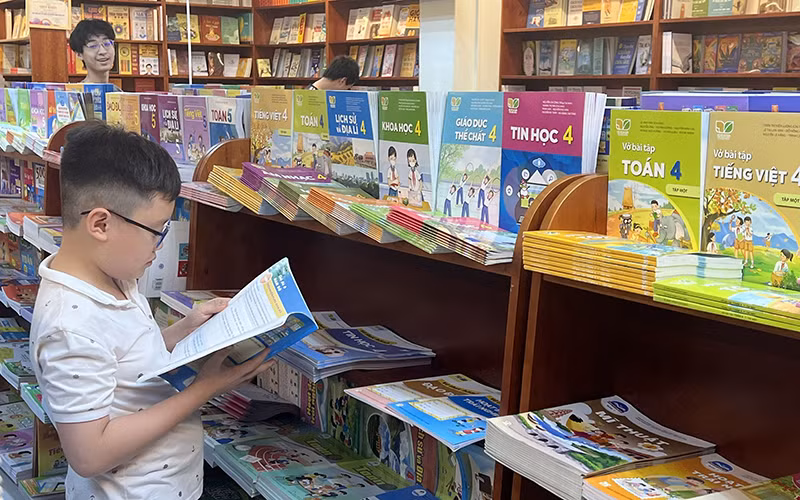Học sinh lựa chọn sách giáo khoa tại nhà sách. (Ảnh NGUYÊN KHÔI)