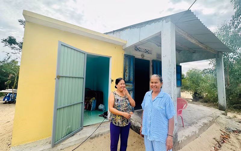 Mẹ con chị Phan Thị Mỹ Nhung ở xã Tam Thanh, thành phố Tam Kỳ bên căn phòng tránh bão.