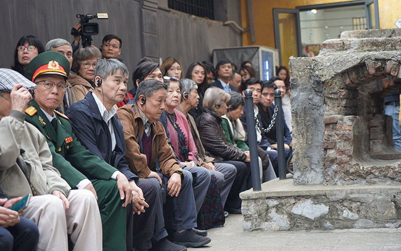 Các đại biểu ôn lại ký ức xưa bên hiện vật ống cống ngầm - phương tiện vượt ngục lịch sử (năm 1945) tại Di tích Nhà tù Hỏa Lò.