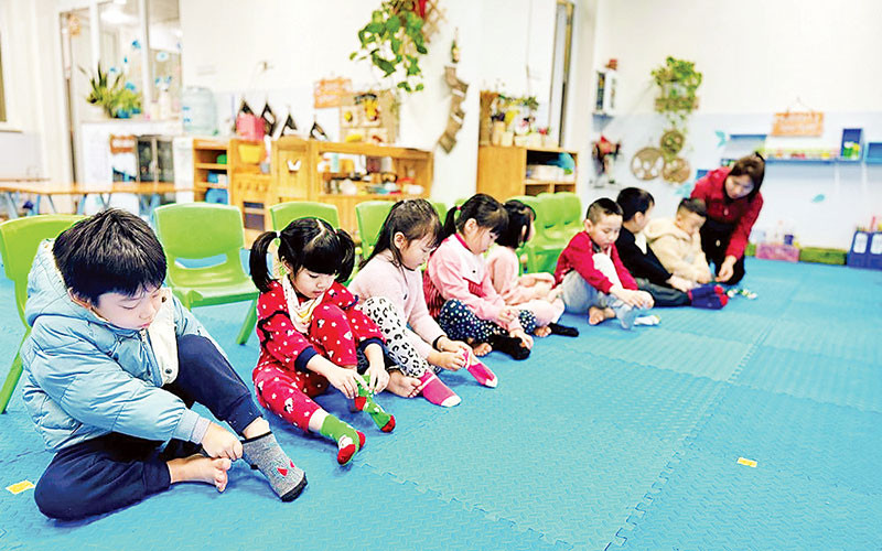 Cô giáo Trường mầm non số 6 (quận Ba Đình) hướng dẫn trẻ cách giữ ấm cơ thể khi trời lạnh.