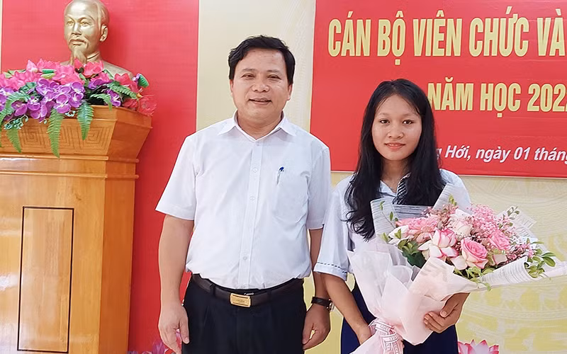 Lãnh đạo Trường phổ thông dân tộc nội trú tỉnh tặng quà của Bí thư Tỉnh ủy Quảng Bình cho em Cao Thị Lệ Hằng.