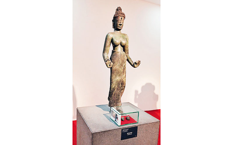 Tượng Bồ tát Tara và hai di vật đóa sen và con ốc trong hộp kính đặt dưới chân tượng. (Ảnh do Bảo tàng Điêu khắc Chăm cung cấp)
