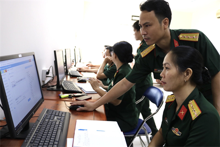 Cán bộ Ban Công nghệ thông tin Quân khu 7 hướng dẫn cán bộ, nhân viên Cục Chính trị Quân khu sử dụng phần mềm hệ thông tin chỉ đạo, điều hành.