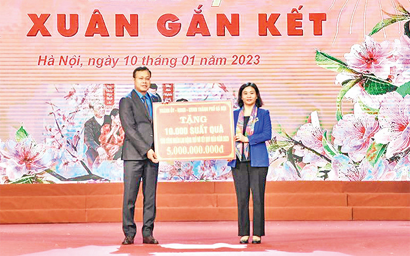 Phó Bí thư Thường trực Thành ủy Nguyễn Thị Tuyến trao quà và vé xe về quê đón Tết cho công nhân lao động. (Ảnh THANH HẢI) 