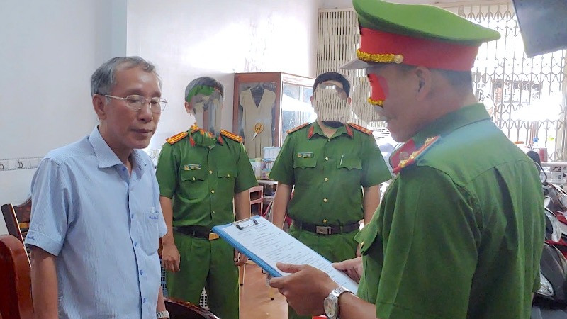 Lực lượng chức năng đọc lệnh bắt tạm giam ông Tô Quang Phúc (bìa trái), cựu Giám đốc Quỹ đầu tư phát triển tỉnh Cà Mau (ảnh Công an cung cấp). 