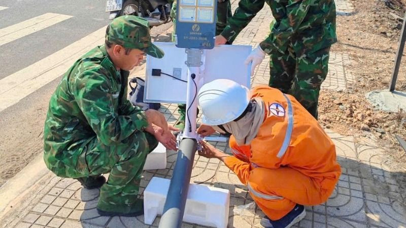 Cán bộ, chiến sĩ Đồn Biên phòng Bo Heng và cán bộ, nhân viên Điện lực thi công công trình.