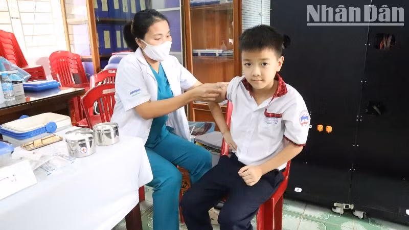 Cán bộ Trạm Y tế phường Tân Lợi, thành phố Buôn Ma Thuột tiêm vaccine phòng sởi cho học sinh trên địa bàn.