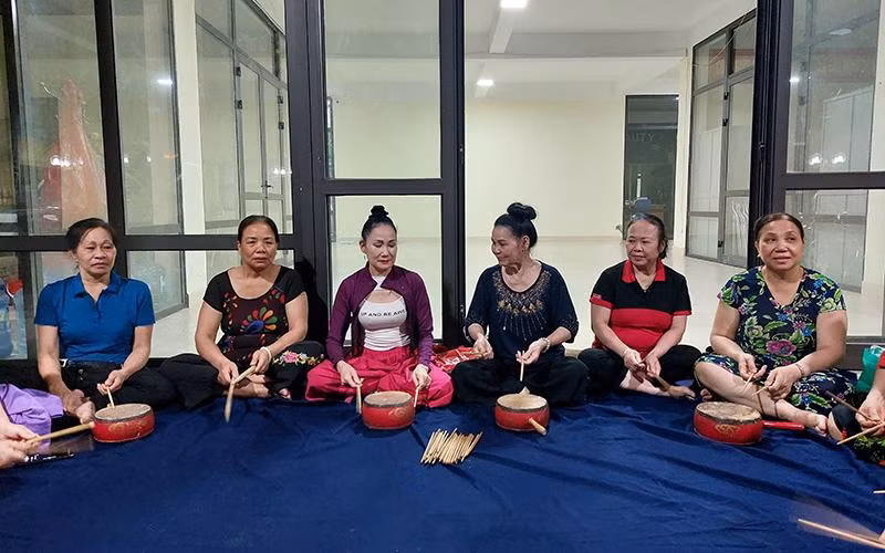 Nghệ nhân trống hội Nguyễn Thị Minh Tám (người thứ tư từ trái sang) miệt mài truyền dạy cho các hội viên Câu lạc bộ trống hội phường Nghĩa Đô, quận Cầu Giấy.