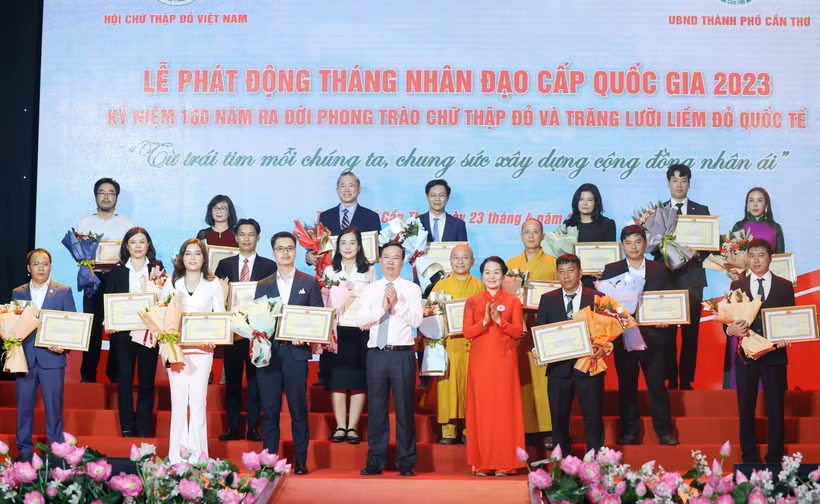 Chủ tịch nước Võ Văn Thưởng, Chủ tịch danh dự Hội Chữ thập Đỏ Việt Nam và bà Bùi Thị Hòa, Chủ tịch Hội Chữ thập Đỏ Việt Nam tặng hoa và trao bảng Ghi nhận tấm lòng vàng nhân đạo. (Ảnh: TTXVN) 