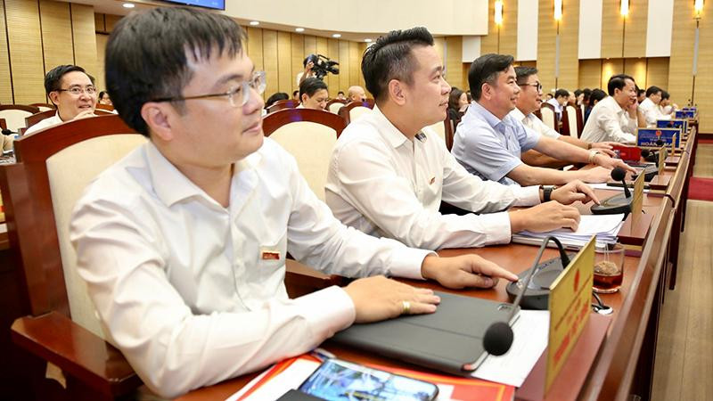 Các đại biểu biểu quyết thông qua nghị quyết. (Ảnh: DUY LINH)