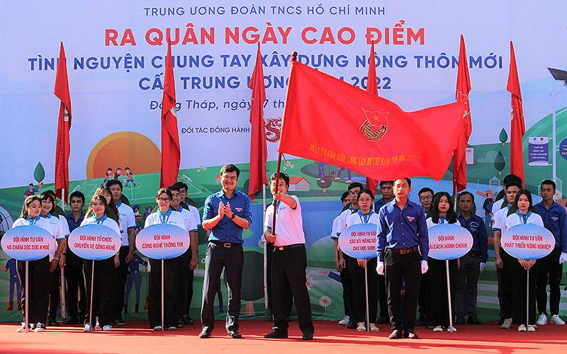 Đồng chí Bùi Quang Huy, Ủy viên dự khuyết Trung ương Đảng, Bí thư Thường trực Trung ương Đoàn (bên trái, hàng đầu) trao cờ tình nguyện cho Đội hình “Trí thức trẻ chuyển giao tiến bộ kỹ thuật” tại xã Tân Kiều (huyện Tháp Mười, tỉnh Đồng Tháp).