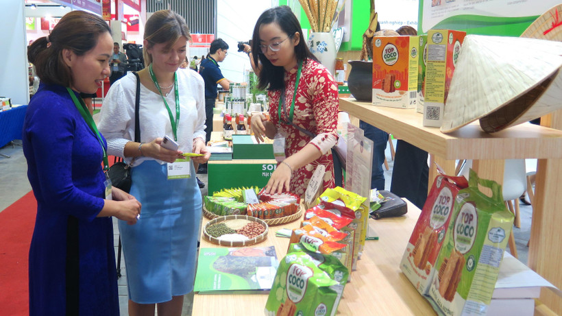 Khách tham quan, tìm hiểu sản phẩm tại một gian hàng thực phẩm tại Triển lãm.