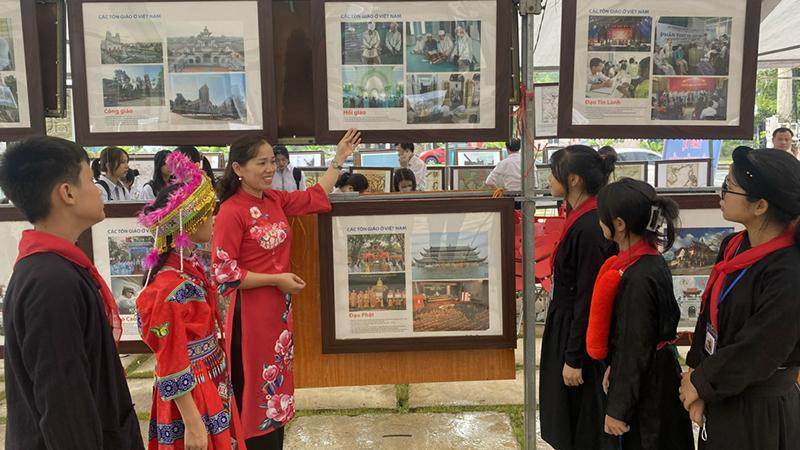 Giới thiệu cho học sinh dân tộc về hình ảnh tại triển lãm.