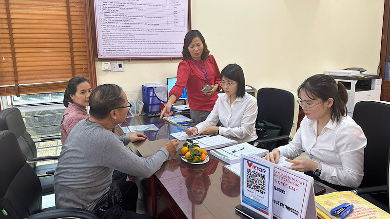 Cán bộ ngân hàng hướng dẫn người dân mở tài khoản để thực hiện chi trả an sinh xã hội không dùng tiền mặt. 