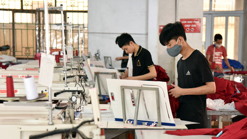 Công nhân Công ty cổ phần Nam Tiệp (Cụm công nghiệp An Xá, thành phố Nam Ðịnh, tỉnh Nam Ðịnh) may quần áo xuất khẩu. (Ảnh TRẦN HẢI) 