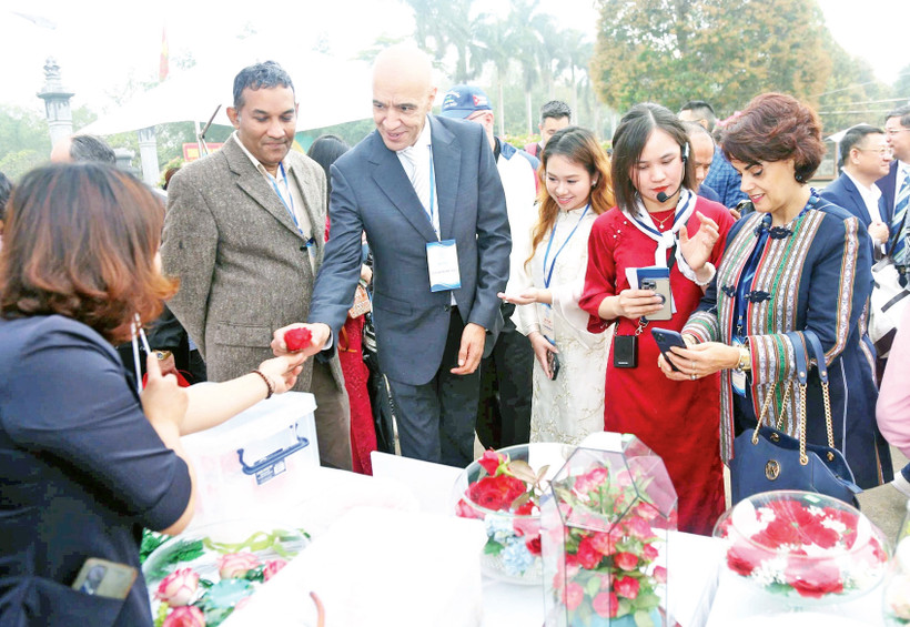 Các đại biểu quốc tế trải nghiệm làm "hoa bất tử" trong chương trình Du xuân hữu nghị 2025. 