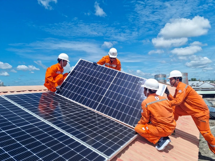 Công nhân Tổng công ty Điện lực Thành phố Hồ Chí Minh lắp đặt hệ thống điện mặt trời trên mái nhà. (Ảnh NAM DƯƠNG) 
