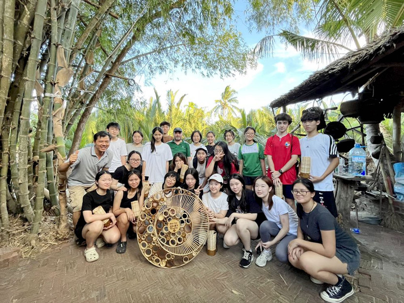 Du khách trải nghiệm một lớp học làm đồ thủ công mỹ nghệ từ tre, dừa. 