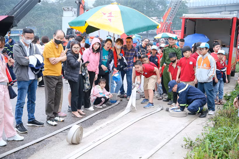 Cảnh sát PCCC và CNCH quận Thanh Xuân (Hà Nội) hướng dẫn người dân sử dụng các thiết bị phòng cháy, chữa cháy. (Ảnh NAM PHONG)