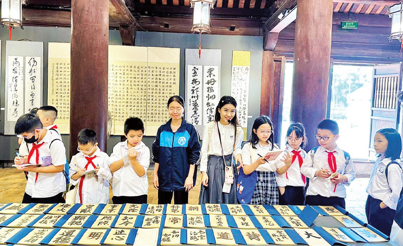 Học sinh Thủ đô tham quan, tìm hiểu các hoạt động văn hóa truyền thống tại di tích Văn Miếu-Quốc Tử Giám. 