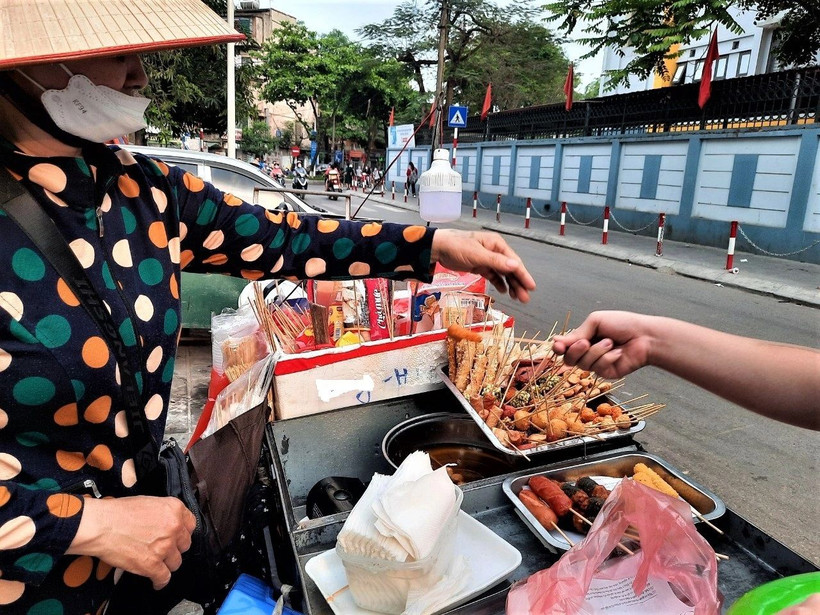 Những quán hàng rong với nhiều loại thức ăn, nước uống được bày bán tại khu vực cổng trường học không bảo đảm vệ sinh an toàn thực phẩm. (Ảnh ĐỖ VI) 