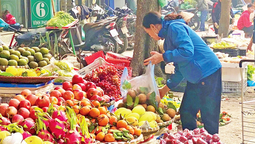 Người dân mua hoa quả tại chợ Vĩnh Phúc (quận Ba Đình, Hà Nội). 